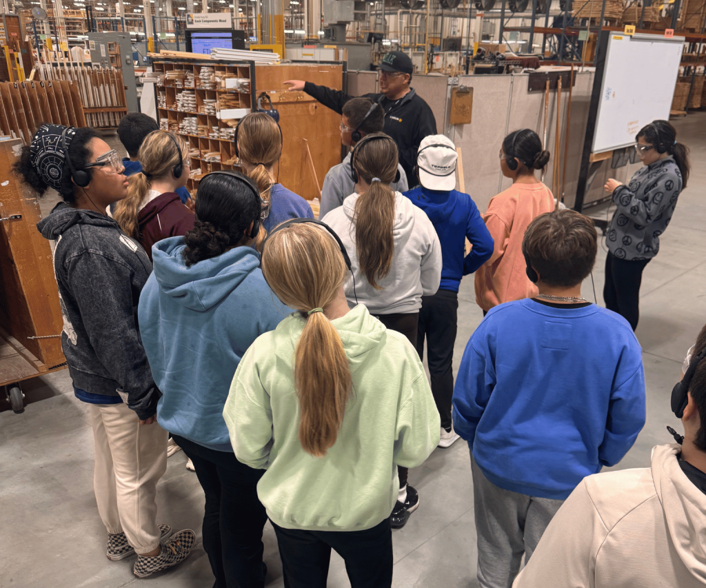 Students learning about window manufacturing.